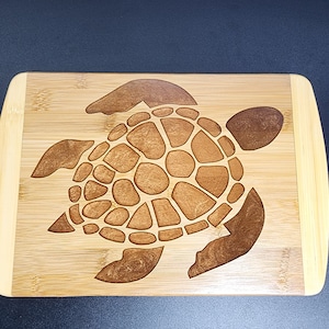 Skär-/serveringsbräda av sköldpadda. CNC-skuren och fylld med epoxiharts. Kan hängas upp som väggkonst.