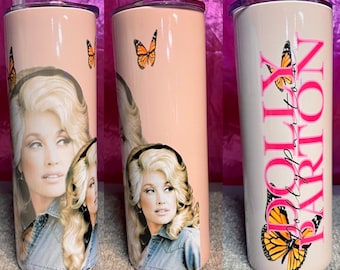 Puede incluir: Un vaso de acero inoxidable rosa con tapa blanca y una imagen de Dolly Parton con mariposas. El texto "Dolly Parton" está escrito en rosa en el vaso.