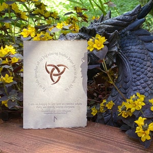 Viking card with a Rune depicting the word Joy and a Horn of Odin, in front of some flowers and a garden statue of a dragon head