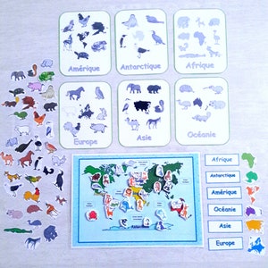 May include: A world map with continents labeled in blue and white.  There are colorful animal stickers on the map, and separate cards with animals and continent names.  The cards are labeled "Africa", "Antarctica", "America", "Oceania", "Asia", and "Europe".