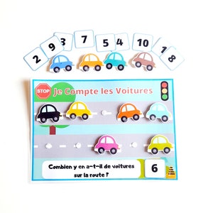 Peut inclure: Un jeu éducatif coloré pour enfants avec une route sur laquelle on voit six voitures et un panneau stop. Le jeu comprend une question demandant combien de voitures sont sur la route, avec la réponse 6. Le jeu comprend également des cartes numérotées de 1 à 10.