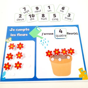 May include: A colourful educational game for learning French counting with a watering can, flowers, and number cards. The game includes the words 'Je compte les fleurs' and 'J'arrose' in French.