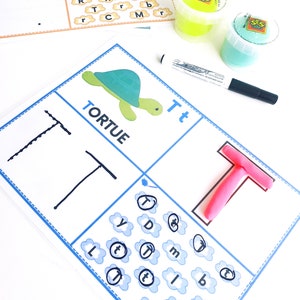 May include: A worksheet for learning the letter 'T' with a picture of a turtle, the word 'TORTUE', and the letter 'T' written in lowercase and uppercase. The worksheet also includes a section for tracing the letter 'T' and a section for finding the letter 'T' hidden among other letters.