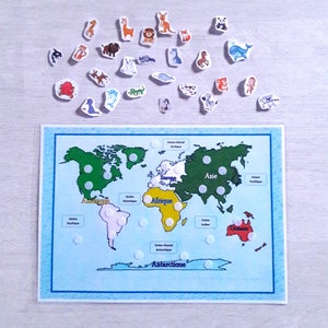 May include: A world map with continents labeled in French, including "Amerique", "Afrique", "Europe", "Asie", and "Antarctique".  The map has white dots on each continent, and there are small animal stickers around the map.