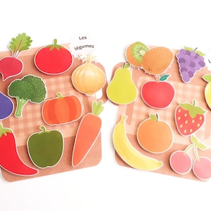 May include: A set of colorful felt fruit and vegetable shapes with French labels. The fruits are kiwi, orange, apple, strawberry, lemon, grapes, and cherries. The vegetables are onion, carrot, eggplant, pepper, pumpkin, broccoli, radish, and chili pepper.