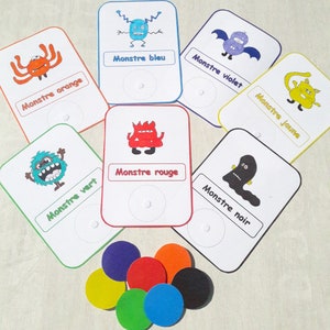 May include: A set of six colorful monster cards with matching colored circles. Each card features a different monster with a French word describing the color of the monster. The words are "Monstre orange", "Monstre bleu", "Monstre vert", "Monstre rouge", "Monstre violet", and "Monstre jaune".
