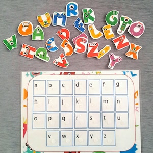 May include: A colorful alphabet learning chart with a grid of letters a-z. Each letter is in a separate square with a white circle in the center. There are colorful monster letters scattered around the chart.