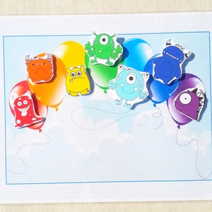 May include: A card with a rainbow of balloons, each with a different colorful monster on it. The monsters have different features, including horns, teeth, and eyes.