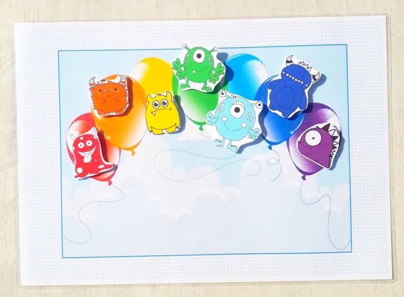 May include: A card with a rainbow of balloons, each with a different colorful monster on it. The monsters have different features, including horns, teeth, and eyes.