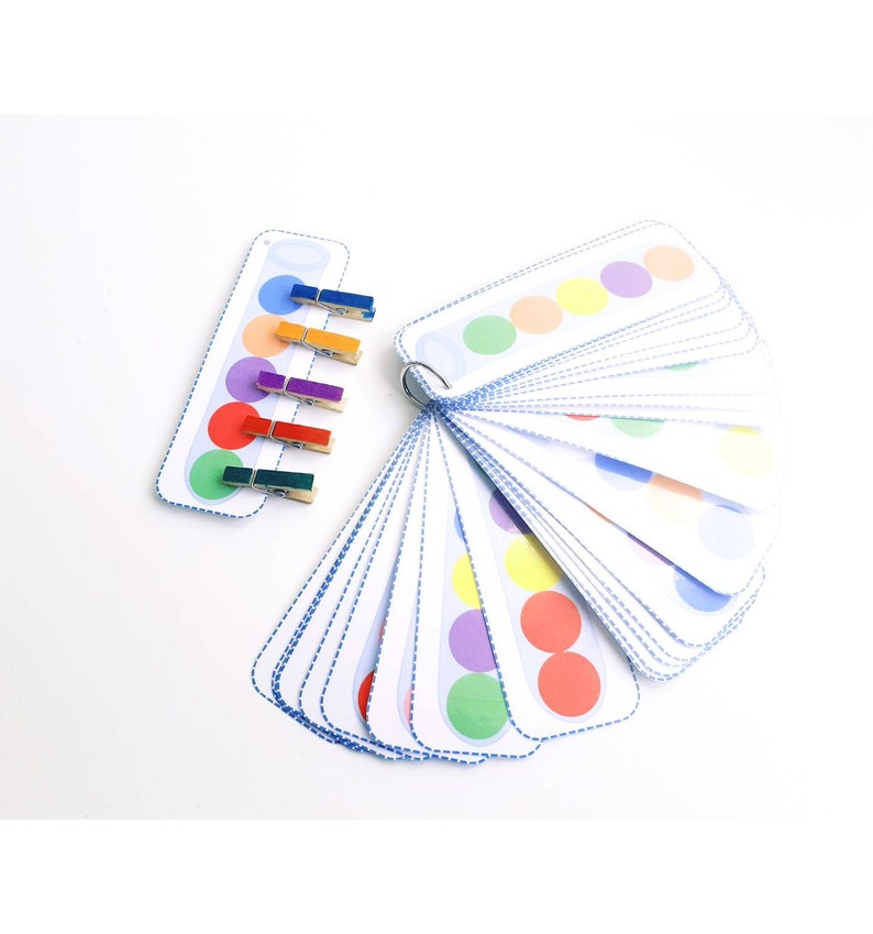 Puede incluir: Un conjunto de tarjetas de c&iacute;rculo de colores con pinzas para la ropa a juego. Las tarjetas est&aacute;n dispuestas en forma de abanico y presentan una variedad de colores, incluyendo rojo, naranja, amarillo, verde, azul, morado y rosa.
