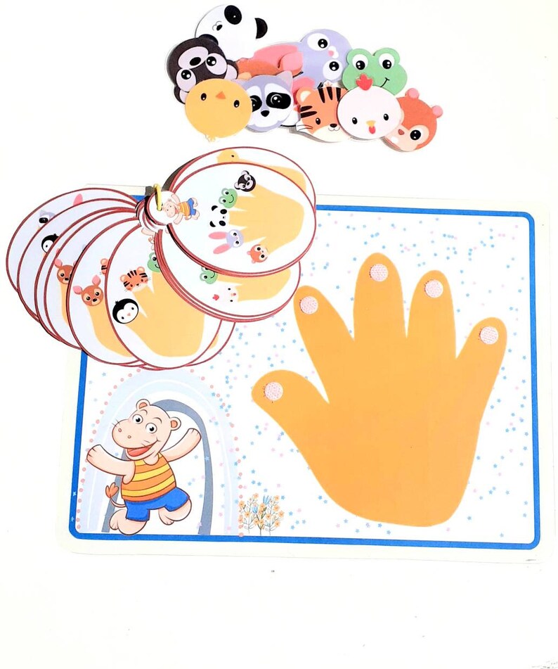 May include: A colorful educational game for kids featuring a hand with five fingers and various animal faces. The game includes a set of cards with different animal faces and a large hand with five fingers. The game is designed to help children learn about animals and their names.