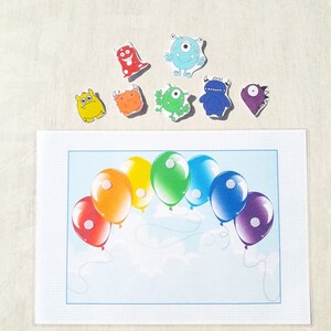 May include: A rainbow-colored balloon arch with white polka dots, a blue background, and white clouds. There are eight colorful monster stickers on a white background above the balloon arch.