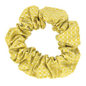 May include: A yellow scrunchie with a white geometric pattern. The fabric is gathered and ruffled, creating a textured appearance. This hair accessory is a stylish addition to any hairstyle.