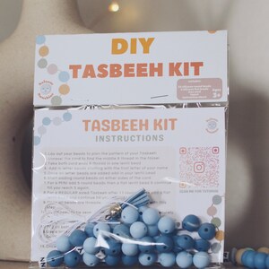 May include: A DIY Tasbeeh kit with blue beads, white cord, and a tassel. The kit includes instructions and a QR code for a tutorial. The packaging has a colorful design with the words "Salaam Sunshine" and "DIY Tasbeeh Kit".
