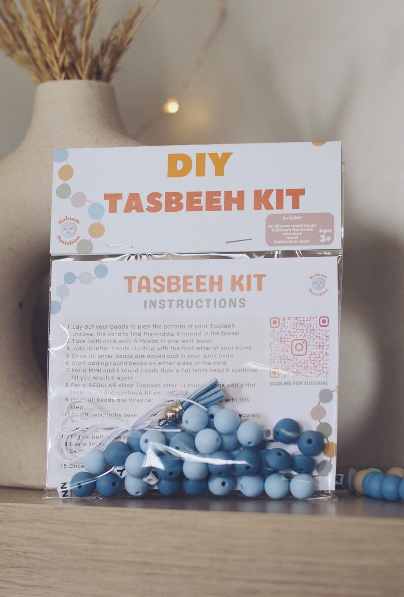 May include: A DIY Tasbeeh kit with blue beads, white cord, and a tassel. The kit includes instructions and a QR code for a tutorial. The packaging has a colorful design with the words "Salaam Sunshine" and "DIY Tasbeeh Kit".