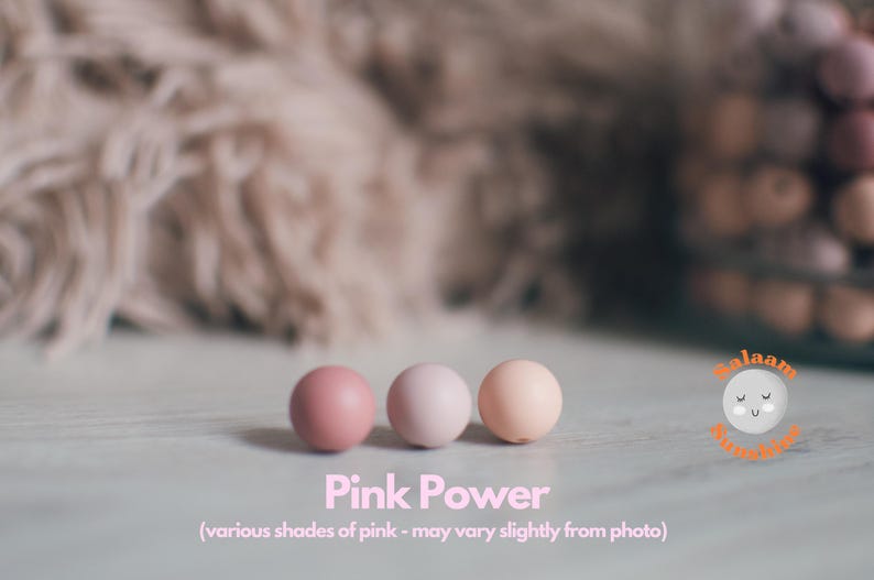 May include: Three round beads in various shades of pink. The beads are arranged in a row on a white surface. The text "Pink Power" is written below the beads. The text "(various shades of pink - may vary slightly from photo)" is written below the text "Pink Power".
