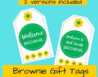 Könnte beinhalten: Zwei weiße Geschenkanhänger mit einem grünen Kreis mit der Aufschrift "Welcome BROWNIE" und "Welcome to girl Scouts BROWNIE". Die Anhänger haben gelbe Blumenakzente und befinden sich auf einem türkisfarbenen Hintergrund. Der Text "Brownie Gift Tags" befindet sich in einem gelben Banner.