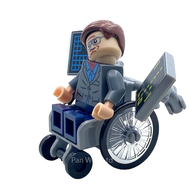 May include: A Lego minifigure of a person in a wheelchair, wearing glasses, a gray suit, and a blue shirt. The figure has brown hair and is holding two black screens. The wheelchair has black wheels and a gray frame.