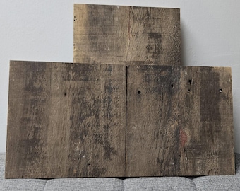 May include: Three reclaimed wood panels with a rustic, weathered look. The panels are made of dark brown wood with a natural grain pattern. They are perfect for adding a touch of rustic charm to any home decor project.