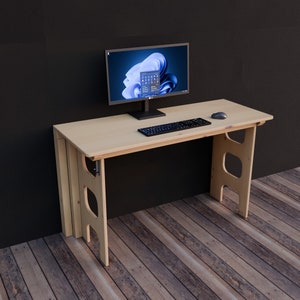 May include: A light wood computer desk with a black computer monitor, keyboard, and mouse. The desk has a simple design with two open shelves on each side.
