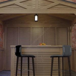 Op de afbeelding: Een houten buitenbar met een latten dak en twee zwarte barstoelen. De bar staat tegen een bakstenen muur en heeft een houten aanrecht met wat fruit erop.