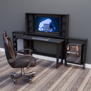 May include: A black gaming desk setup with a large monitor, keyboard, and computer tower. The desk has built-in storage and is paired with a black and red gaming chair. The setup is against a grey wall and on a wood floor.