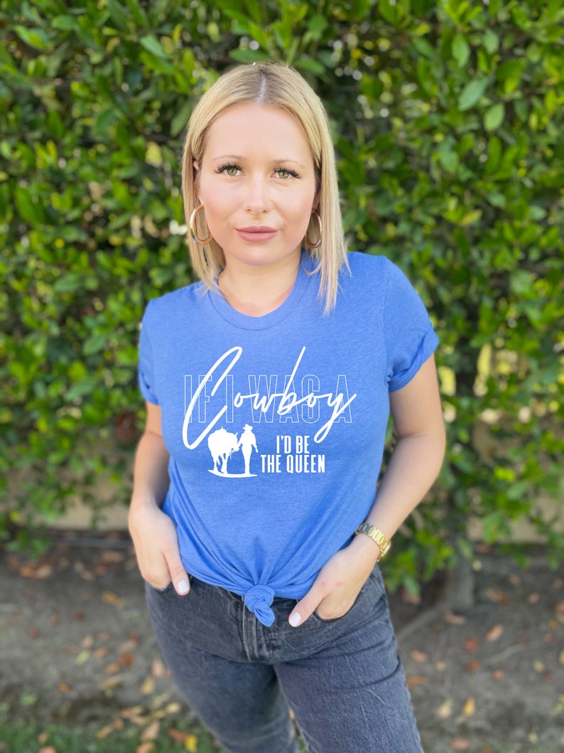 Peut inclure: Un t-shirt bleu avec un motif blanc qui dit "Si j'&eacute;tais un cowboy, je serais la reine".
