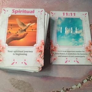 May include: Two cards with pink floral borders. The first card has a white dove flying over a sunset with the text "Spiritual!" and "Your spiritual journey is beginning". The second card has a blue sky with the text "11:11" and "11:11 is an important number for Twin Flames, it symbolises the harmony and balance of soul counterparts".