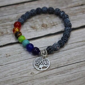 May include: A black lava stone bracelet with a rainbow of chakra beads and a silver tree of life charm.