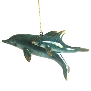Bring a touch of the ocean into your home with this beautifully crafted set of 2 dolphin ornaments