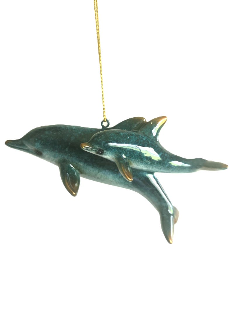 Bring a touch of the ocean into your home with this beautifully crafted set of 2 dolphin ornaments