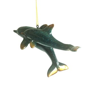Bring a touch of the ocean into your home with this beautifully crafted set of 2 dolphin ornaments
