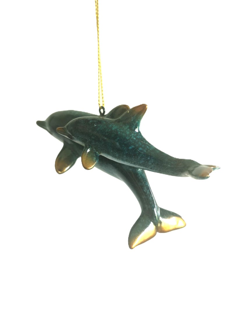 Bring a touch of the ocean into your home with this beautifully crafted set of 2 dolphin ornaments