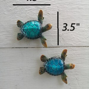 A charming figurine of a cartoon-style blue turtle, crafted with whimsical details. The turtle has a bright blue shell adorned with playful patterns, and its cute expression exudes a sense of friendliness