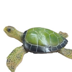 Majestic turtle figurine exuding a sense of grandeur and charm. The intricate details showcase the graceful curves and patterns on the shell, while the subdued yet rich color palette adds a touch of elegance