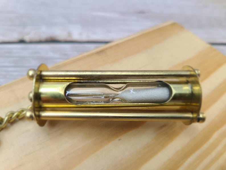 Discover the elegance of time with our Handmade Brass Sand Timer Keychain. Crafted with skillful artistry, this miniature hourglass captures the essence of both functionality and aesthetic appeal.