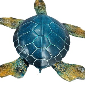 Elegant sea turtle figurine with lifelike details and a serene pose. The intricate patterns on the shell and the subdued color palette capture the beauty of this marine creature. Perfect for adding a touch of oceanic charm to your decor
