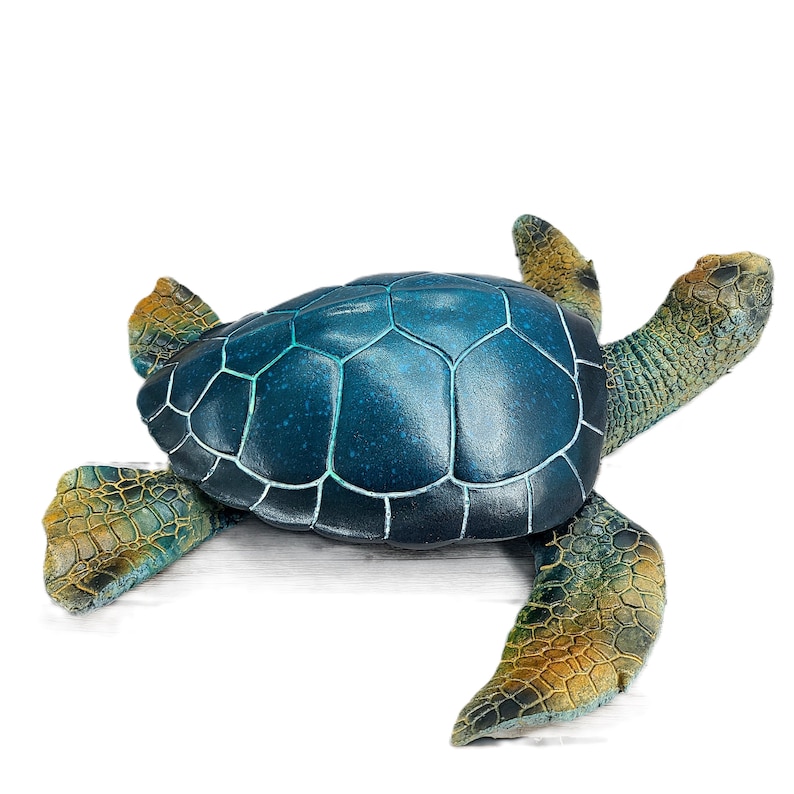Elegant sea turtle figurine with lifelike details and a serene pose. The intricate patterns on the shell and the subdued color palette capture the beauty of this marine creature. Perfect for adding a touch of oceanic charm to your decor