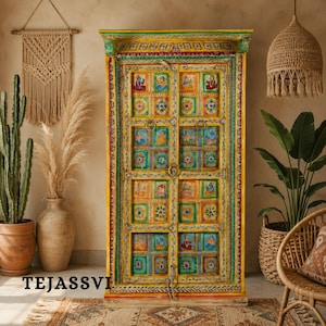 May include: A vibrant, hand-painted wooden cabinet with double doors. The cabinet features a yellow base with colorful square panels, each depicting a unique design. Green and red trim frames the doors and top. The text "TEJASSVI" is visible at the bottom.