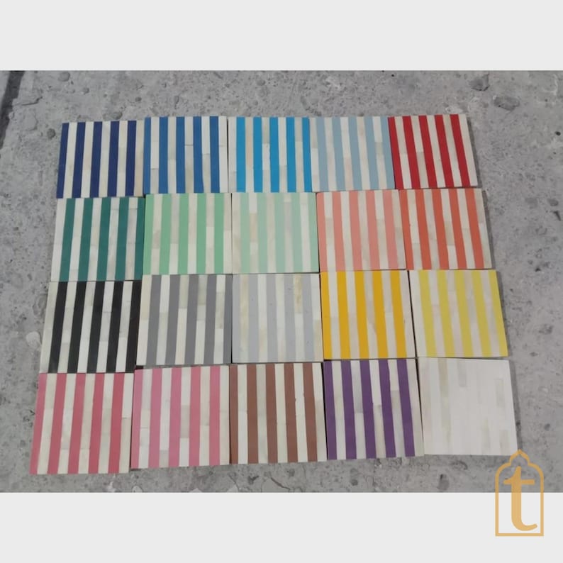 Op de afbeelding: Een verzameling rechthoekige decoratieve tegels met verticale strepen in verschillende kleuren, waaronder blauw, groen, roze en geel. Elke tegel heeft een witte achtergrond met strepen. De tegels zijn in een rasterpatroon gerangschikt.