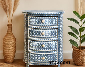 Può includere: Un comò blu e bianco a fantasia con quattro cassetti e pomelli rotondi. Il comò ha un fronte curvo ed è decorato con un motivo geometrico. Il comò è in legno e ha un bordo decorativo.