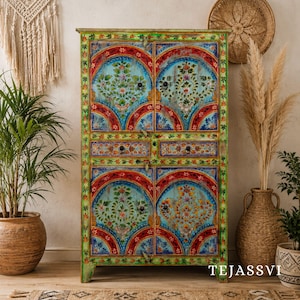 Peut inclure: Un buffet en bois peint à la main avec un motif floral vibrant. Le buffet présente un fond bleu clair avec des accents rouges et verts. Les portes et les tiroirs sont ornés de motifs floraux complexes, créant un meuble coloré et artistique.