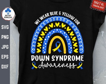 Może przedstawiać: Czarny T-shirt z wzorem tęczy w kolorze niebieskim i żółtym. Tęcza ma żółte serca i białe kropki. Tekst "We wear blue & yellow for Down Syndrome Awareness" jest napisany białymi literami.