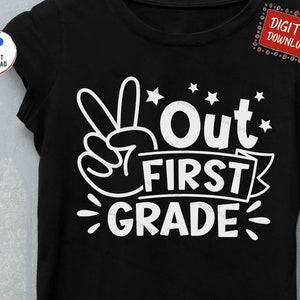 Puede incluir: Una camiseta negra con un dise&ntilde;o blanco que dice "Out First Grade" con un signo de paz y estrellas.