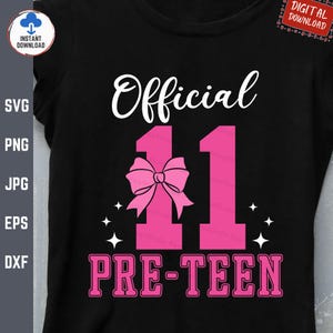 Op de afbeelding: Een zwart T-shirt met de tekst "Official 11 Pre-Teen" in roze en witte letters. Een roze strik bevindt zich boven het getal 11.