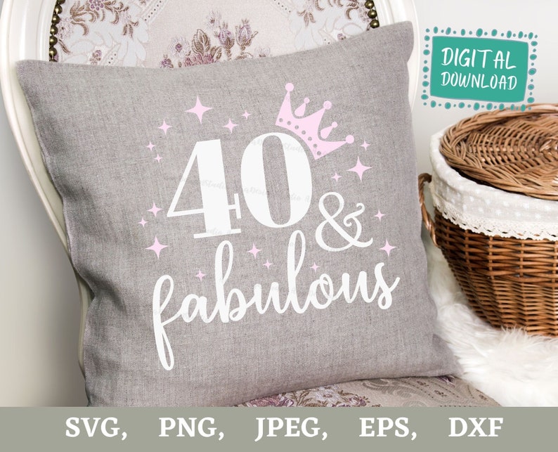 Puede incluir: Una almohada gris con el texto "40 & fabulous" en blanco con una corona rosa y estrellas. La almohada est&aacute; sobre una superficie blanca.