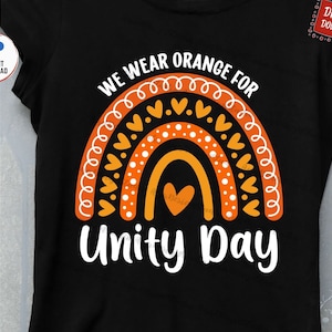 May include: Black t-shirt featuring a vibrant rainbow design in orange and white, with the words "WE WEAR ORANGE FOR UNITY DAY". The design incorporates hearts and dots. Digital download available.