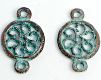 May include: Two antique silver-toned metal connector charms with a circular filigree design in a teal blue patina finish. The charms have two loops on the top and bottom for attaching to jewelry.