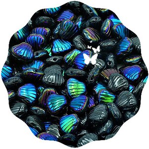 May include: A large pile of iridescent black and blue glass beads shaped like seashells. The beads have a shimmering, holographic effect.