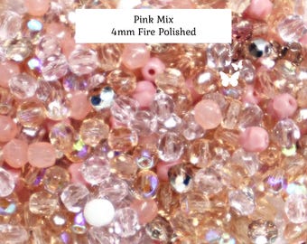 May include: A collection of 4mm fire polished beads in a pink mix, featuring translucent, opaque, and iridescent glass beads in shades of light pink, peach, and clear. The text Pink Mix 4mm Fire Polished is printed on a white rectangular overlay.